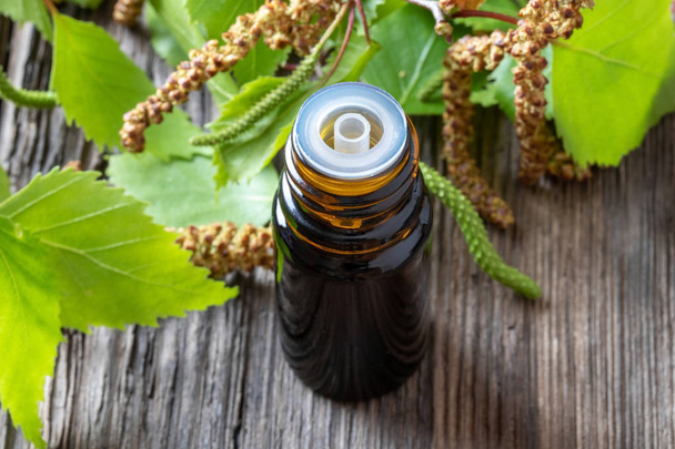 Una botella de aceite esencial de abedul con ramas de abedul
 - Foto, imagen