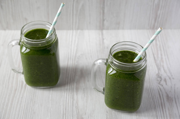 Green smoothie with avocado, spinach and banana in glass jars ov - Photo, Image
