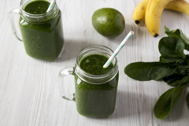 Green smoothie with avocado, spinach and banana in glass jars ov - Foto, Bild