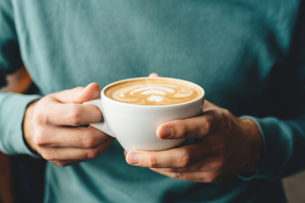 A xícara de cappuccino nas mãos dos homens
 - Foto, Imagem