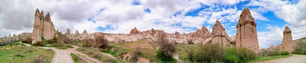 Panoramic view of the Love valley with huge phallus shape stones in Goreme village, Turkey. Rural Cappadocia landscape. Volcanic mountains in Goreme national park. Countryside lifestyle. - Photo, Image
