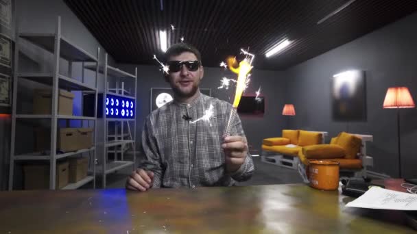 Cute zabawny facet w kratkę trzyma i fale z podświetlane świecące zimne ognie - Materiał filmowy, wideo