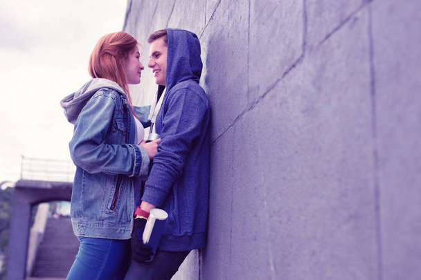 Passionate young couple having lovely moments while leaning on the wall - Fotoğraf, Görsel