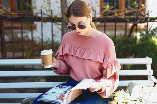 menina com café e revista no banco
 - Foto, Imagem