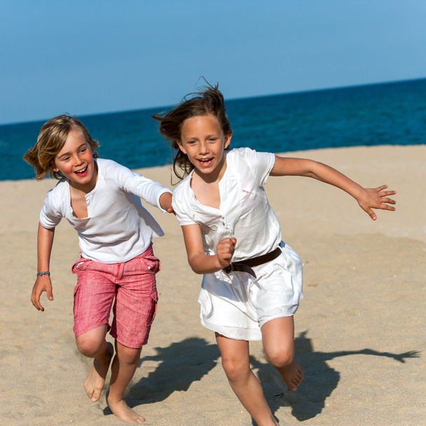 αγόρι κυνηγούν κορίτσι στην παραλία. - Φωτογραφία, εικόνα
