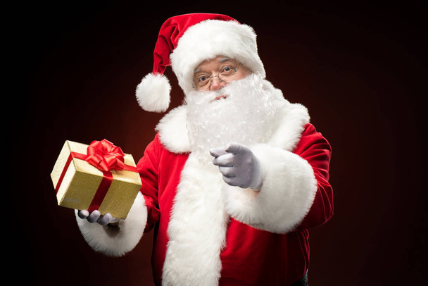 Happy Santa Claus with gift box in hand - Фото, зображення