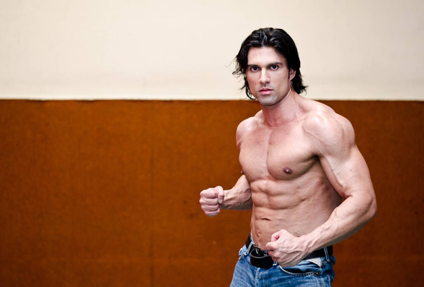 Attractive shirtless muscular man in jeans indoors with ripped torso, abs, pecs and arms - Φωτογραφία, εικόνα