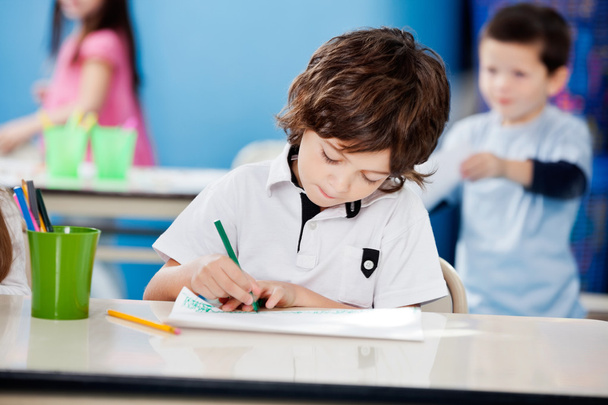 Boy Drawing With Sketch Pen At Desk In Kindergarten - Fotografie, Obrázek