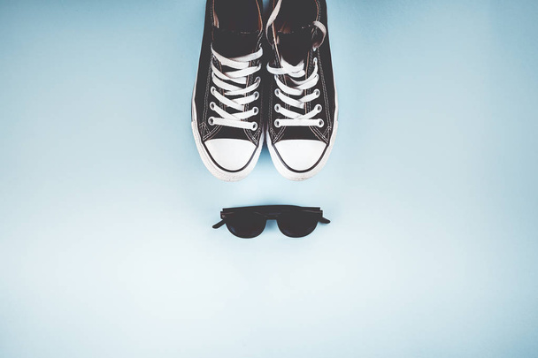 Turnschuhe und Brille auf blauem Hintergrund - Foto, Bild