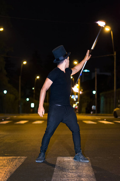 Um artista de rua que faz um show em Lima - Peru, fazendo malabarismos com um pau no semáforo pára
 - Foto, Imagem
