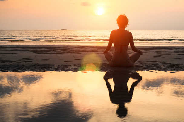 Yoga vrouw op een strand - Foto, afbeelding