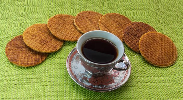 Stroopwafels in the shape of an arch arranged on the table with a coffee cup - Fotoğraf, Görsel