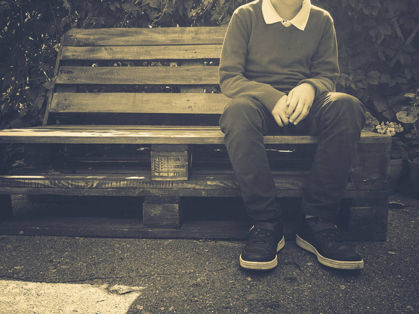 tyylikäs poika istuu puinen penkki
 - Valokuva, kuva