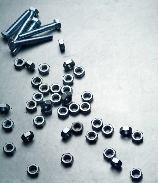 Nuts and screws on a metal plate - Photo, Image