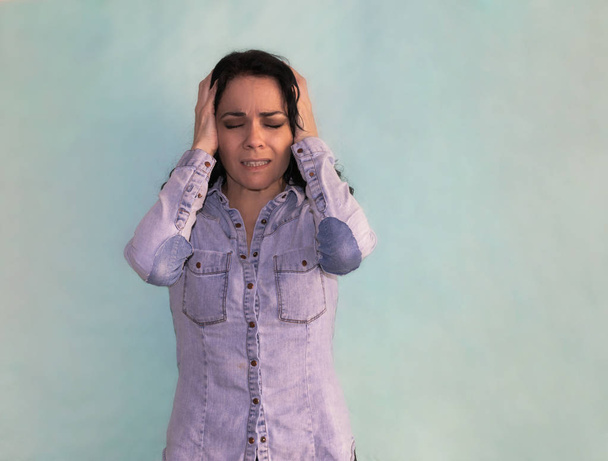 Bruna donna che soffre di mal di testa ed emicrania disperata con le mani sulla testa
 - Foto, immagini