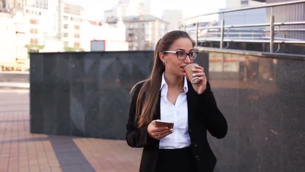 Koffie tijd van lachende zakenvrouw met smartphone op City Street. Stabiel schot - Video