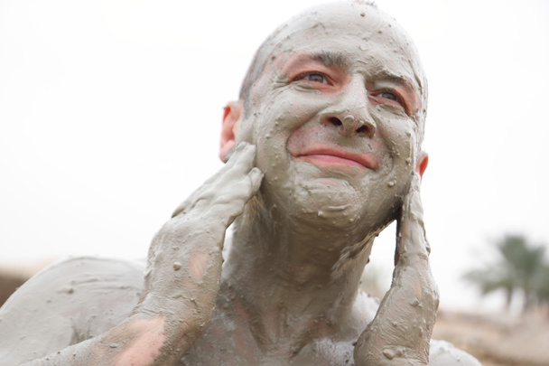 Man receives mud treatment - Foto, Imagen