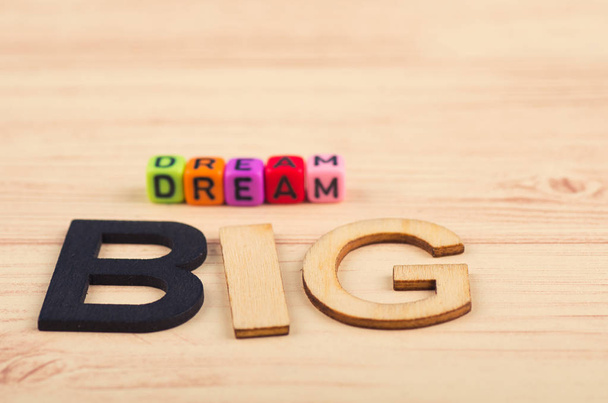 üzleti motivációs és inspiráló idézetek, színes kockák szavak Dream Big a fából készült íróasztal - Fotó, kép