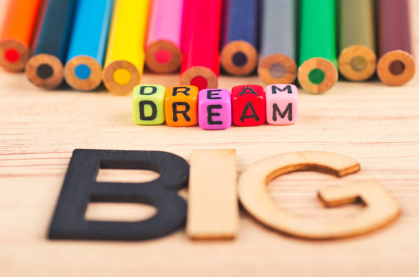 üzleti motivációs és inspiráló idézetek, színes kockák szavak Dream Big a fából készült íróasztal - Fotó, kép