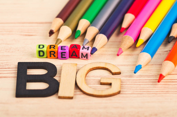 επιχειρηματική κίνητρα και εμπνευσμένα εισαγωγικά, πολύχρωμα κύβους με τις λέξεις όνειρο μεγάλο σε ξύλινο γραφείο - Φωτογραφία, εικόνα