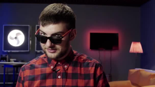 Cute grey eyed guy put on sunglasses speaks, dances and winks at camera - Footage, Video