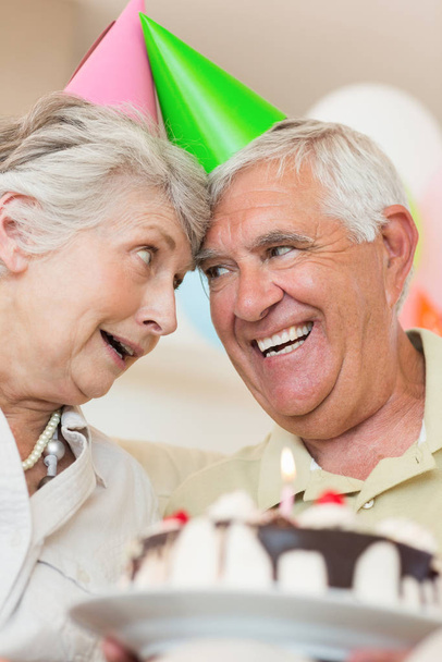 Couple âgé célébrant un anniversaire ensemble à la maison dans le salon
 - Photo, image