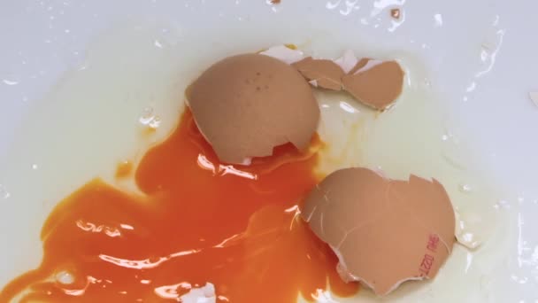 Το ραγισμένο ωμό αυγό ξεπλένεται με νερό που κλείνει τη μακροεντολή - Πλάνα, βίντεο