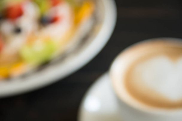 Blurring corazón forma espuma leche Latte arte en taza de café blanco con postre
 - Foto, imagen