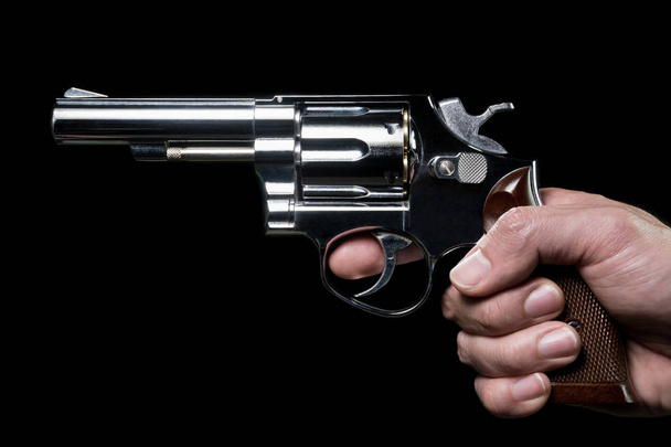 Pistola de acero inoxidable o tirador en la mano humana Vista lateral
 - Foto, imagen