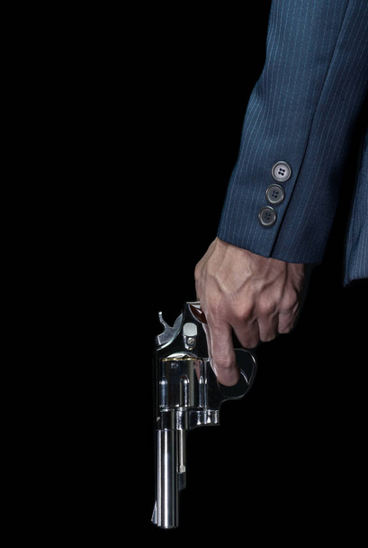 Hombre sostener pistola de acero inoxidable o tirador en la mano izquierda en el libro estilo de la cubierta
 - Foto, imagen