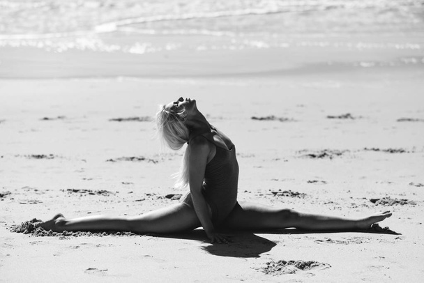 Kaukasisch blonde vrouw het beoefenen van yoga in het strand - Foto, afbeelding