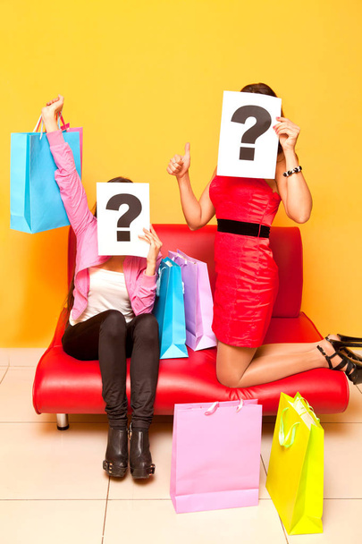 Deux filles faisant du shopping dans un centre commercial avec un point d'interrogation signes
 - Photo, image