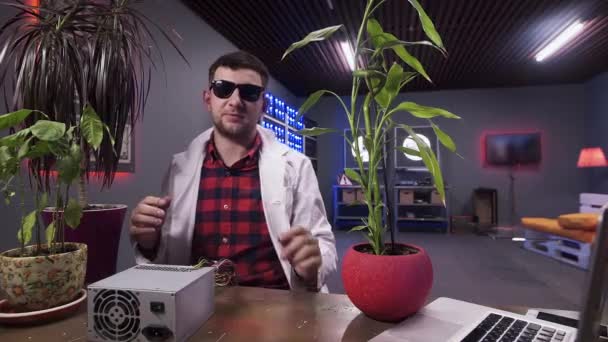 Férfi fehér labor kabát beszél kamera mögött íróasztal egyes növények tálak. - Felvétel, videó