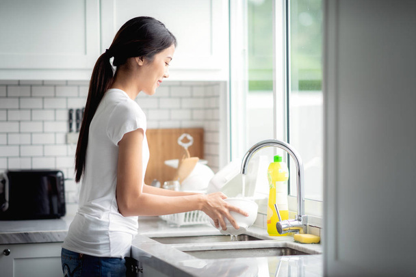 Aziatische Dame wassen een gerecht - Foto, afbeelding