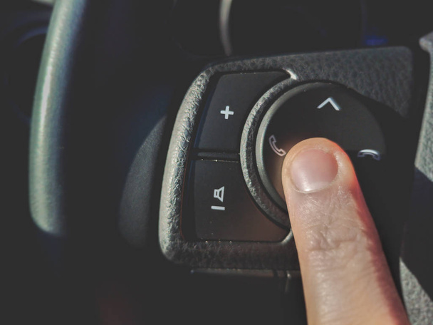 Naciśnij telefon i przyciski regulacji głośności na kierownicy w nowoczesnym samochodzie podświetlenie tła - Zdjęcie, obraz