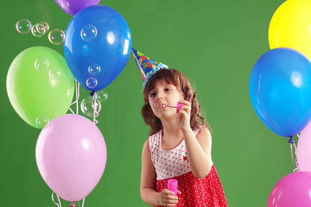 Child celebrating birthday on green studio background - Photo, Image