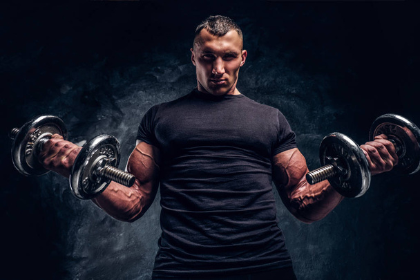 Man  is doing exercises with two dumbbells - Photo, Image