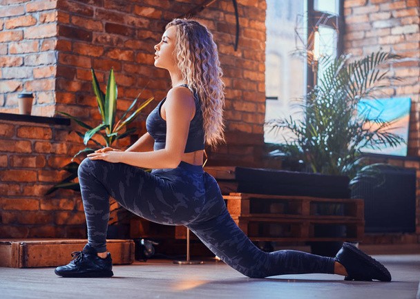 Atractiva mujer positiva para el cuerpo está haciendo ejercicio aeróbico en loft moderno
 - Foto, Imagen