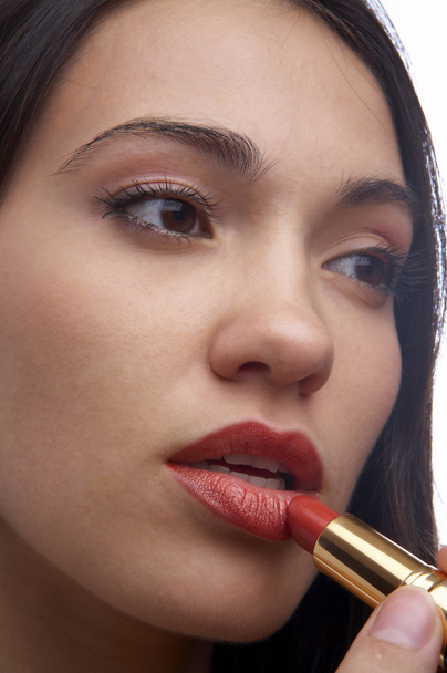 A close-up portrait of a young woman putting on lip liner - Foto, Imagem