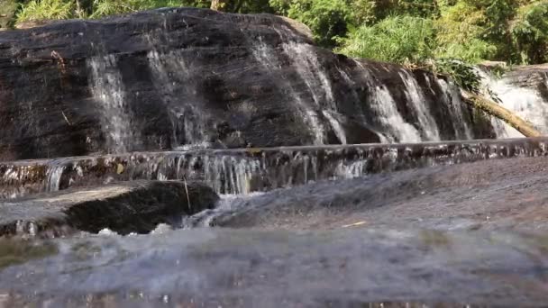 Frontansicht kleiner Wasserfall am Morgen, Wasseroberfläche fließt über Felsen  - Filmmaterial, Video