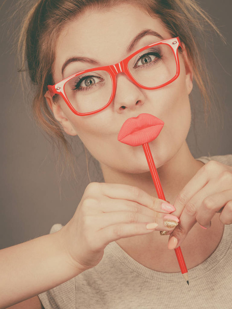 Happy woman holding fake lips on stick - Foto, afbeelding