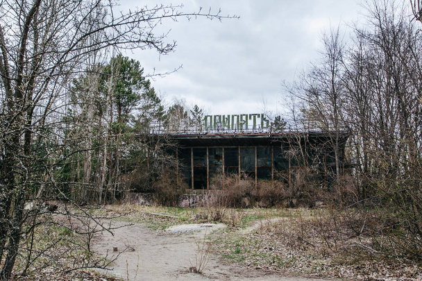 Opuštěná budova zarostlá stromy v Pripjat, černobylské zóně - Fotografie, Obrázek