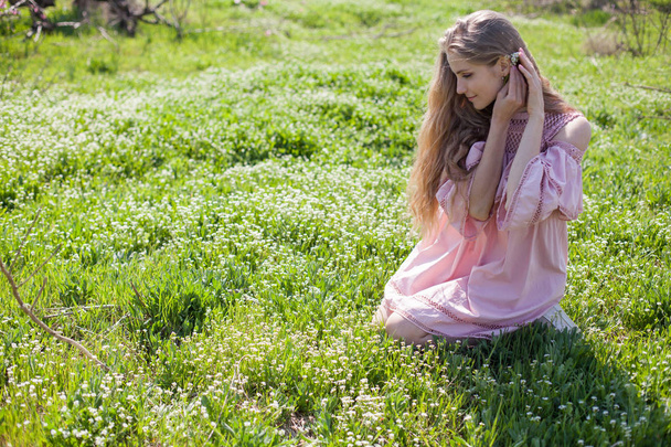 beautiful blonde woman collects spring color in the garden - 写真・画像