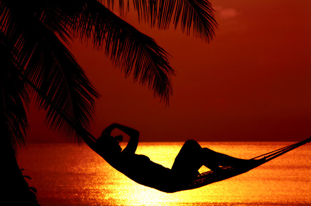 Vista di una donna sdraiata in amaca durante il tramonto
 - Foto, immagini
