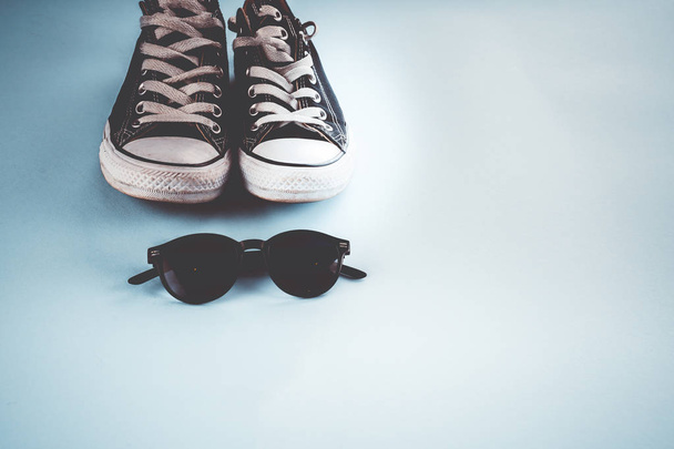 Sneakers and glasses on a blue background - Photo, Image