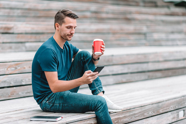 Чоловік читає текстове повідомлення на мобільному телефоні під час ходьби в парку
 - Фото, зображення