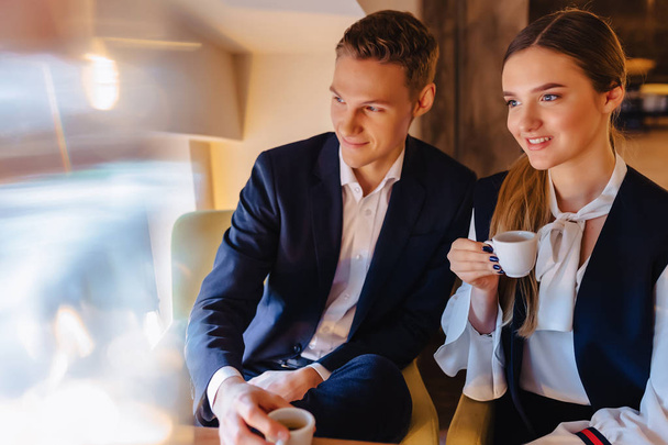 Una elegante pareja bebe café de la mañana en la cafetería, jóvenes empresarios y autónomos
 - Foto, imagen