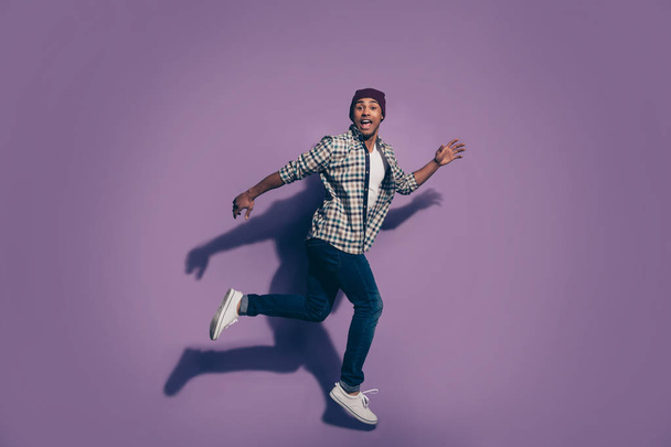 Ful length body size photo portrait of cheerful excited in denim modern trousers white shoes sneakers guy student isolated violet background - Fotoğraf, Görsel