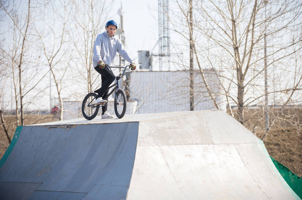 A man on a bicycle on the top of the half pipes - Photo, Image