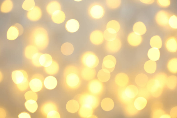 Beautiful golden lights as background. Bokeh effect - Foto, afbeelding